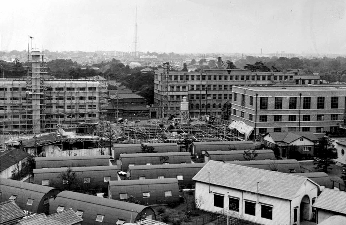 At the left rear is Sophia House under construction (1955). The Quonset huts are in the foreground, with Building No. 1 visible in the background, while the old Building No. 2 is in the middle foreground to the right. 